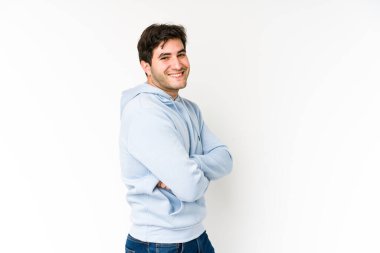 Genç adam beyaz arka planda mutlu, güler yüzlü ve neşeli.