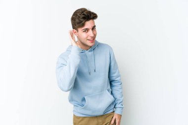 Beyaz arka planda izole edilmiş genç beyaz adam bir dedikoduyu dinlemeye çalışıyor..