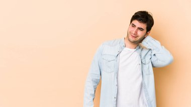 Bej arka planda izole edilmiş genç bir adam sabit yaşam tarzından dolayı boyun ağrısı çekiyor..