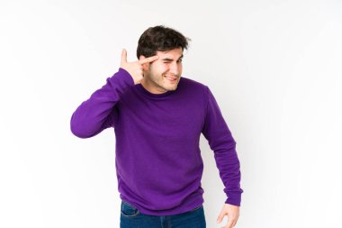 Beyaz arka planda izole edilmiş genç adam işaret parmağıyla bir hayal kırıklığı gösteriyor..