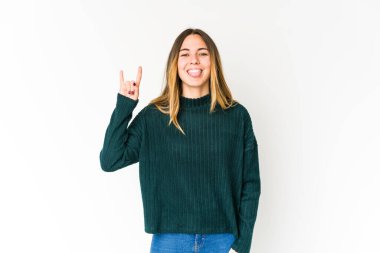 Beyaz arka planda izole edilmiş genç beyaz kadın parmaklarıyla taş hareketi gösteriyor.