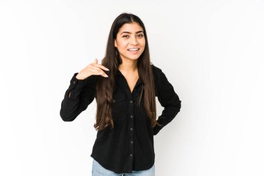 Mor arka planda izole edilmiş genç Hintli bir kadın bir şeye gülüyor, elleriyle ağzını kapatıyor..