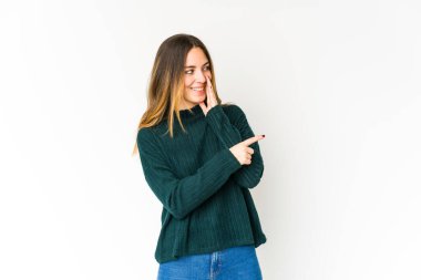 Beyaz arka planda izole edilmiş genç beyaz bir kadın bir dedikodu söylüyor, bir haber sunuyor..