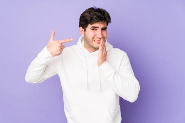 Mor arka planda izole edilmiş genç bir adam güçlü bir diş ağrısı, azıdişi ağrısı var..