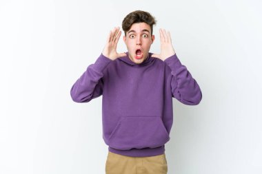 Beyaz arka planda izole edilmiş genç beyaz adam şaşırdı ve şok oldu..