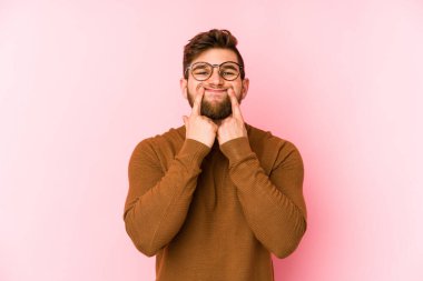 Pembe arka planda izole edilmiş beyaz bir adam iki seçenek arasında şüphe duyuyor..