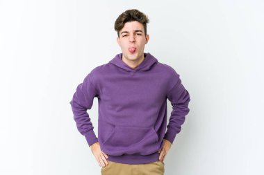 Beyaz arka planda izole edilmiş genç beyaz bir adam. Komik ve dost canlısı bir dil uzatıyor..