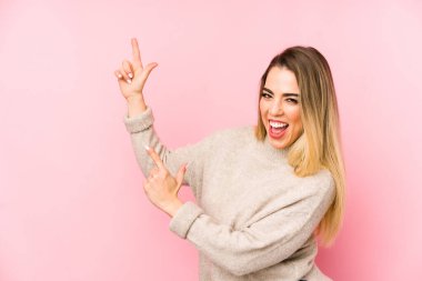 Orta yaşlı bir kadın izole edilmiş arka planda işaret parmaklarıyla fotokopi alanını işaret ederek heyecan ve arzusunu ifade ediyor..