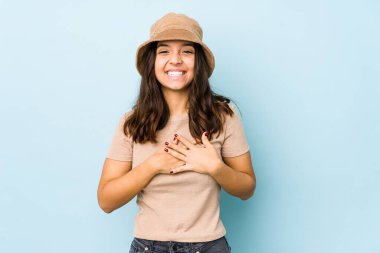 Genç, melez İspanyol kadın gülüyor, elini yüreğine koyuyor, mutluluk kavramını koruyor..