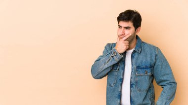 Bej arka planda izole edilmiş genç bir adam. Düşünüyor, bir strateji planlıyor, bir iş yolu düşünüyor..