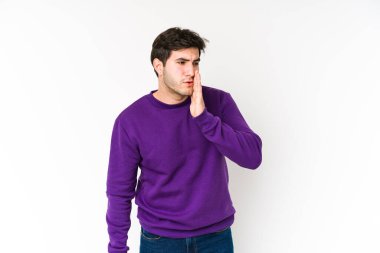 Beyaz arka planda izole edilmiş genç adam gizli bir sıcak fren haberinin olduğunu ve kenara baktığını söylüyor.