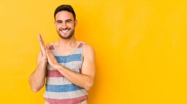 Kafkasyalı genç adam sarı fırında izole edilmiş enerjik ve rahat hissediyor ellerini ovuşturuyor kendinden emin..