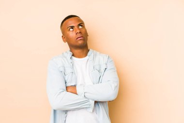 Bej arka planda izole edilmiş genç latin adam tekrarlanan bir görevden yoruldu.