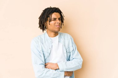Genç Afro-Amerikan Rasta 'lı mutsuz adam iğneleyici ifadesiyle kameraya bakıyor..