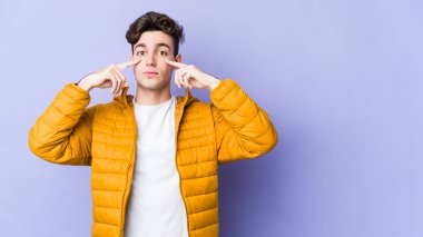 Morarmış arka planda izole edilmiş genç beyaz adam bir göreve odaklanmış, parmaklarını işaret ediyor..