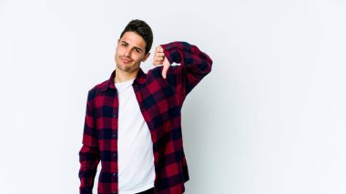 Beyaz arka planda izole edilmiş genç beyaz adam baş parmağını aşağı gösteriyor, hayal kırıklığı konsepti..