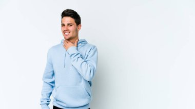 Beyaz arka planda izole edilmiş genç beyaz bir adam kafasının arkasına dokunuyor, düşünüyor ve bir seçim yapıyor..