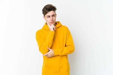 Beyaz arka planda izole edilmiş genç beyaz bir adam bir strateji planlıyor, bir iş yolu düşünüyor..