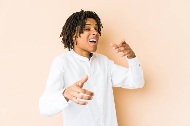 Genç Afro-Amerikan Rasta adamı parmaklarıyla ön tarafı işaret ediyor..