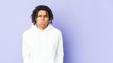 Genç Afrikalı Amerikalı Rasta adamın yanakları şişiyor, yorgun bir ifadesi var. Yüz ifadesi kavramı.