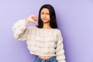 Mor arka planda izole edilmiş genç Çinli bir kadın hoşlanmadığı bir jest gösteriyor. Anlaşmazlık konsepti.