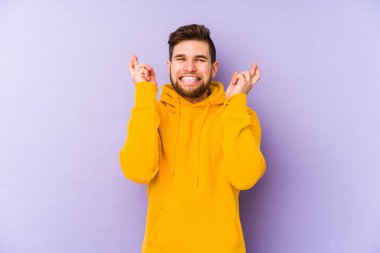 Mor arka planda izole genç adam şans dilemek için şans diliyor.