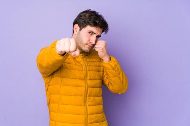 Mor arka planda izole edilmiş genç bir adam bir tartışma yüzünden yumruk, öfke, kavga ve boks atıyor..
