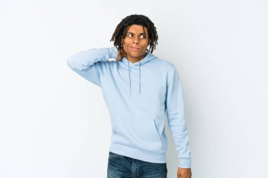 Genç Afrikalı Amerikalı Rasta adam kafasının arkasına dokunuyor, düşünüyor ve bir seçim yapıyor..