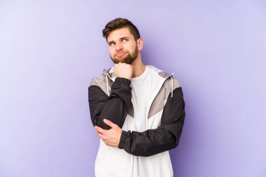 Mor arka planda izole edilmiş genç adam rahatlamış fotokopi odasına bakan bir şey düşünüyor..