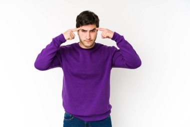 Beyaz arka planda izole edilmiş genç bir adam bir göreve odaklanmış, işaret parmaklarını işaret ediyor..