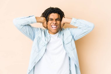 Genç Afro-Amerikan Rasta adam kulaklarını elleriyle kapatıyor yüksek sesle ses duymamaya çalışıyor..