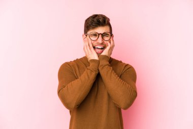 Pembe arka planda yalnız kalmış, ağlayan ve sızlanan genç beyaz bir adam..