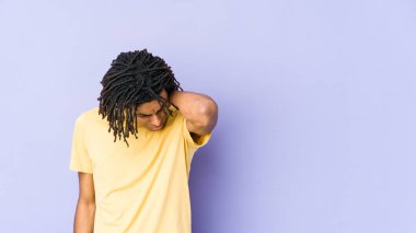 Genç Afro-Amerikan Rasta adam stresten dolayı boynu ağrıyor, masaj yapıyor ve eliyle dokunuyor..