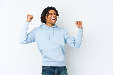 Genç Afrikalı Amerikalı Rasta adam zafer ve galibiyet kavramından sonra yumruğunu kaldırıyor..