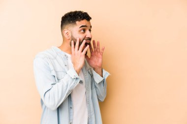 Genç, melez Arap bir adam izole edilmiş yüksek sesle bağırıyor, gözleri açık ve elleri gergin tutuyor..