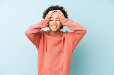 Afrika kökenli Amerikalı küçük çocuk neşeli bir şekilde ellerini başının üstünde tutarak gülüyor. Mutluluk kavramı.