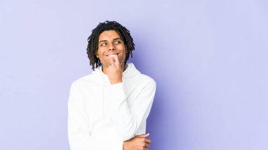 Genç Afrikalı Amerikalı Rasta adam rahatlamış fotokopi odasına bakan bir şey düşünüyor..