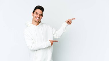 Beyaz arka planda izole edilmiş genç beyaz bir adam işaret parmağıyla işaret ettiği için heyecanlı..