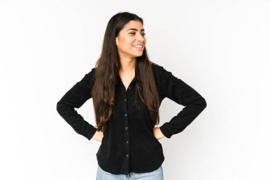 Mor arka planda izole edilmiş genç Hintli kadın mutlu bir şekilde gülüyor ve ellerini karnının üstünde tutarak eğleniyor..