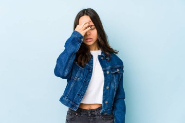 Genç, melez İspanyol bir kadın izole edilmiş, başı ağrıyor, yüzüne dokunuyor..