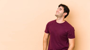 Bej arka planda izole edilmiş genç bir adam gevşemiş ve mutlu bir şekilde gülüyor, boynunda diş izleri var..