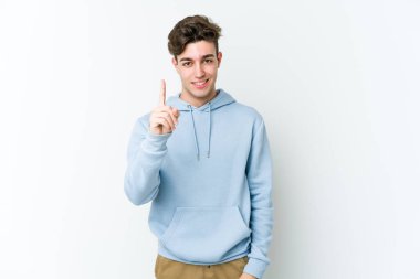 Beyaz arka planda izole edilmiş beyaz tenli genç bir adam bir numarayı parmağıyla gösteriyor..