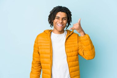 Genç melez adam bir şeye gülüyor, elleriyle ağzını kapatıyor..