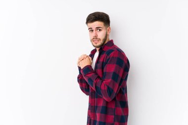 Beyaz arka planda poz veren genç beyaz adam korkmuş ve korkmuş..