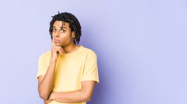 Genç Afro-Amerikan Rasta 'lı mutsuz adam iğneleyici ifadesiyle kameraya bakıyor..