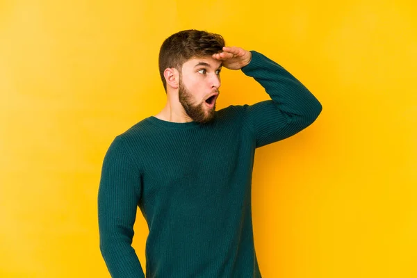 Giovane Uomo Caucasico Isolato Sfondo Giallo Guardando Lontano Tenendo Mano — Foto Stock