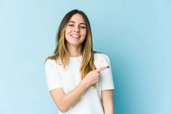 Mladá Běloška Izolovaná Modrém Pozadí Usmívající Ukazující Stranou Ukazující Něco — Stock fotografie