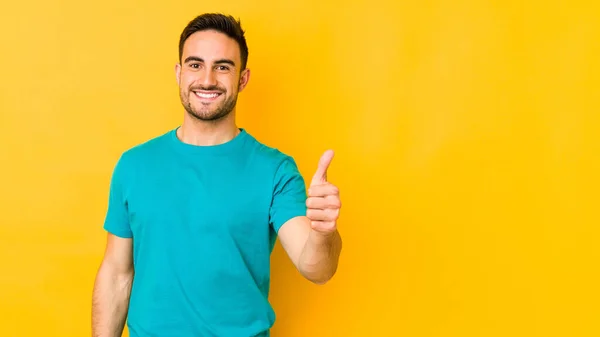 Jovem Caucasiano Isolado Chão Amarelo Sorrindo Levantando Polegar — Fotografia de Stock