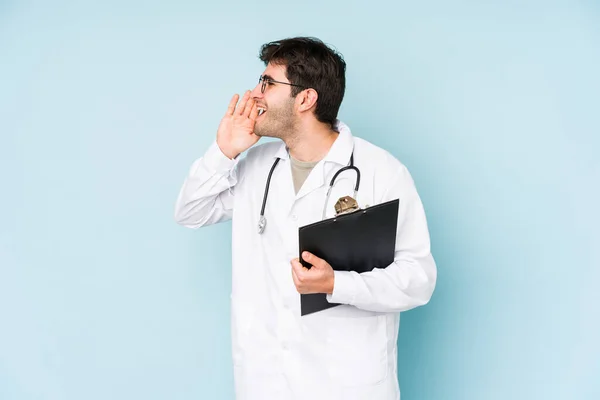 Jovem Médico Homem Isolado Fundo Azul Gritando Segurando Palma Perto — Fotografia de Stock