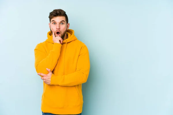 Jovem Caucasiano Isolado Fundo Azul Tendo Alguma Grande Ideia Conceito — Fotografia de Stock